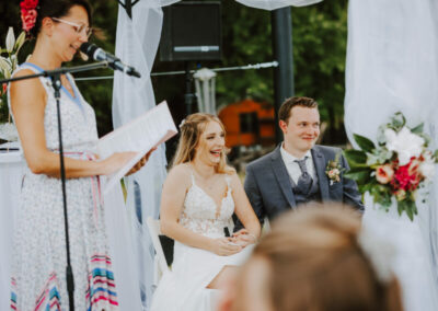 Ein Brautpaar, das während seiner Hochzeitsrede von Mandy Römer pure Freude und Lachen ausstrahlt.